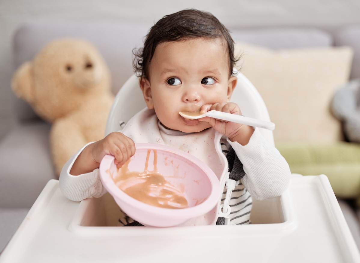 Shot of a baby eating a meal at home image
