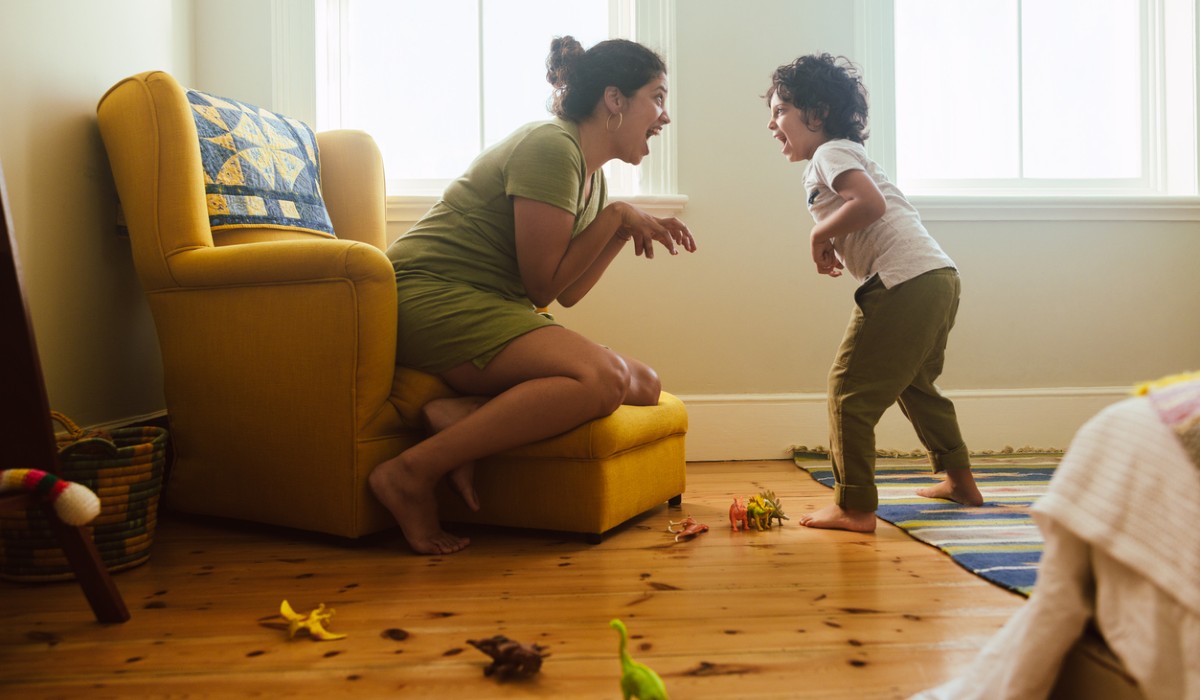 Mother and son imitating a dinosaur at home