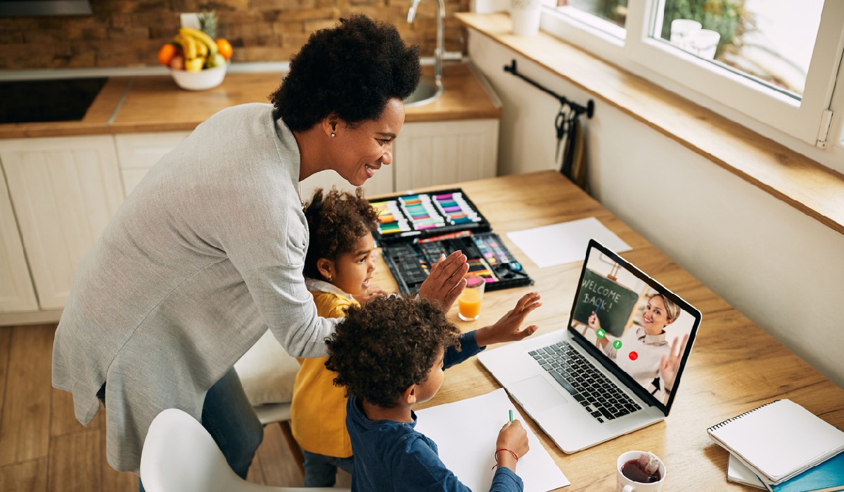 Happy African American family greeting a teacher during a video call over laptop