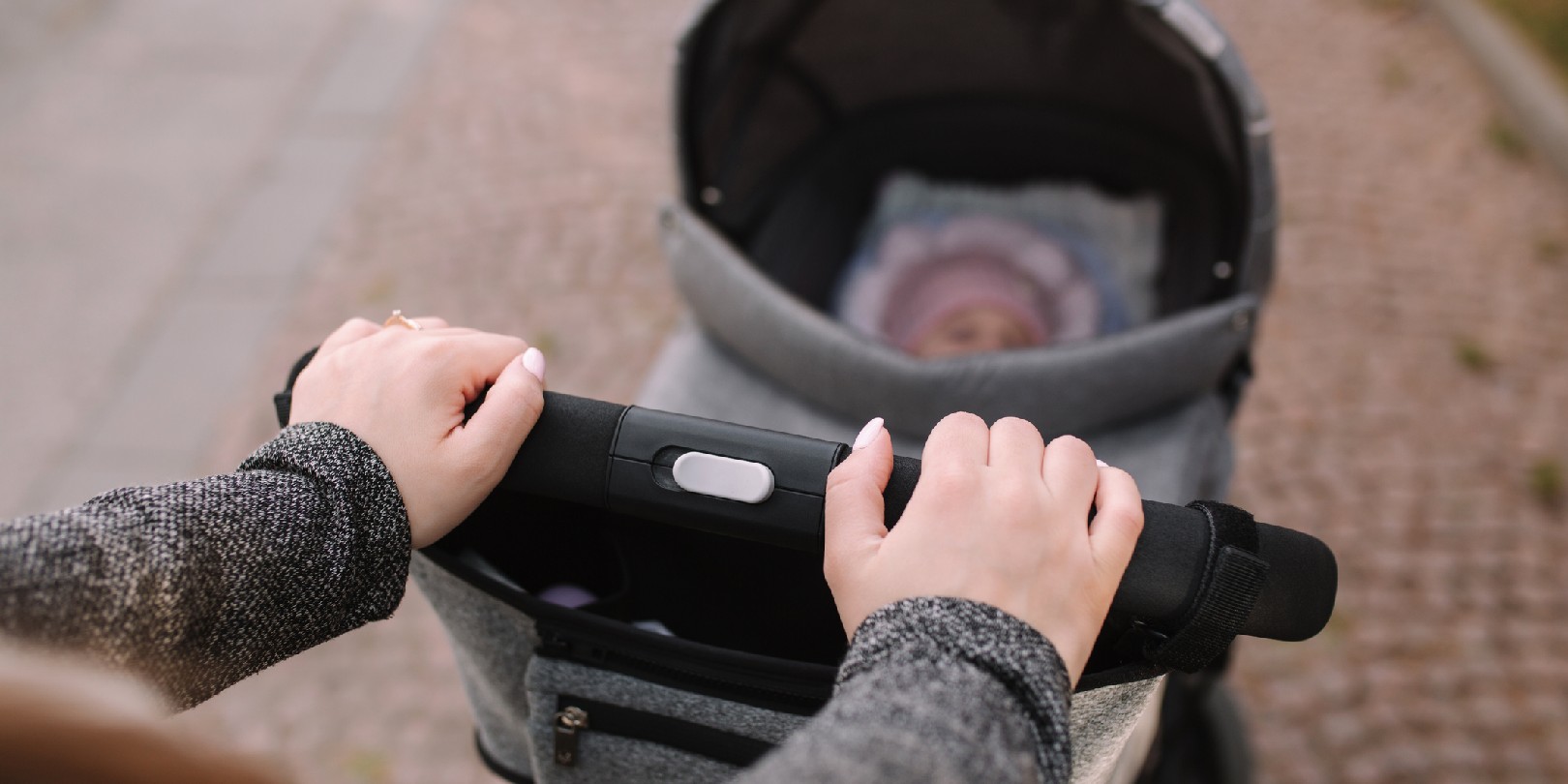 Mother walking with little baby girl in stroller. outside