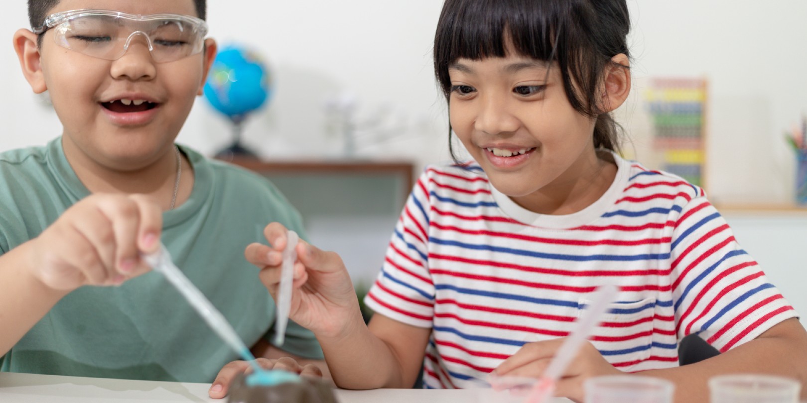 Kids repeating and observing a science lab project at home - the baking soda and vinegar volcano