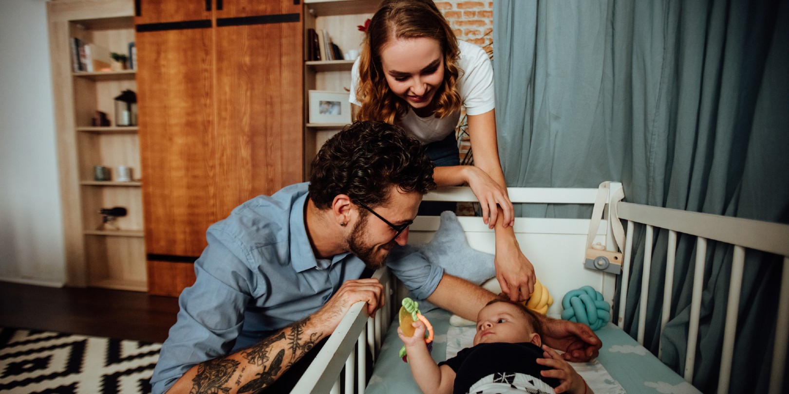 Parents playing with a baby in a crib