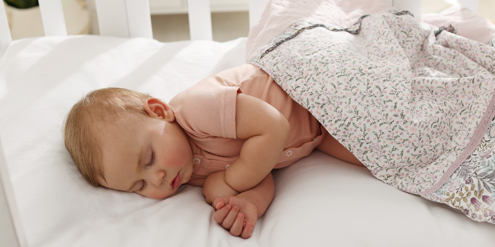 Cute little baby sleeping in soft crib at home