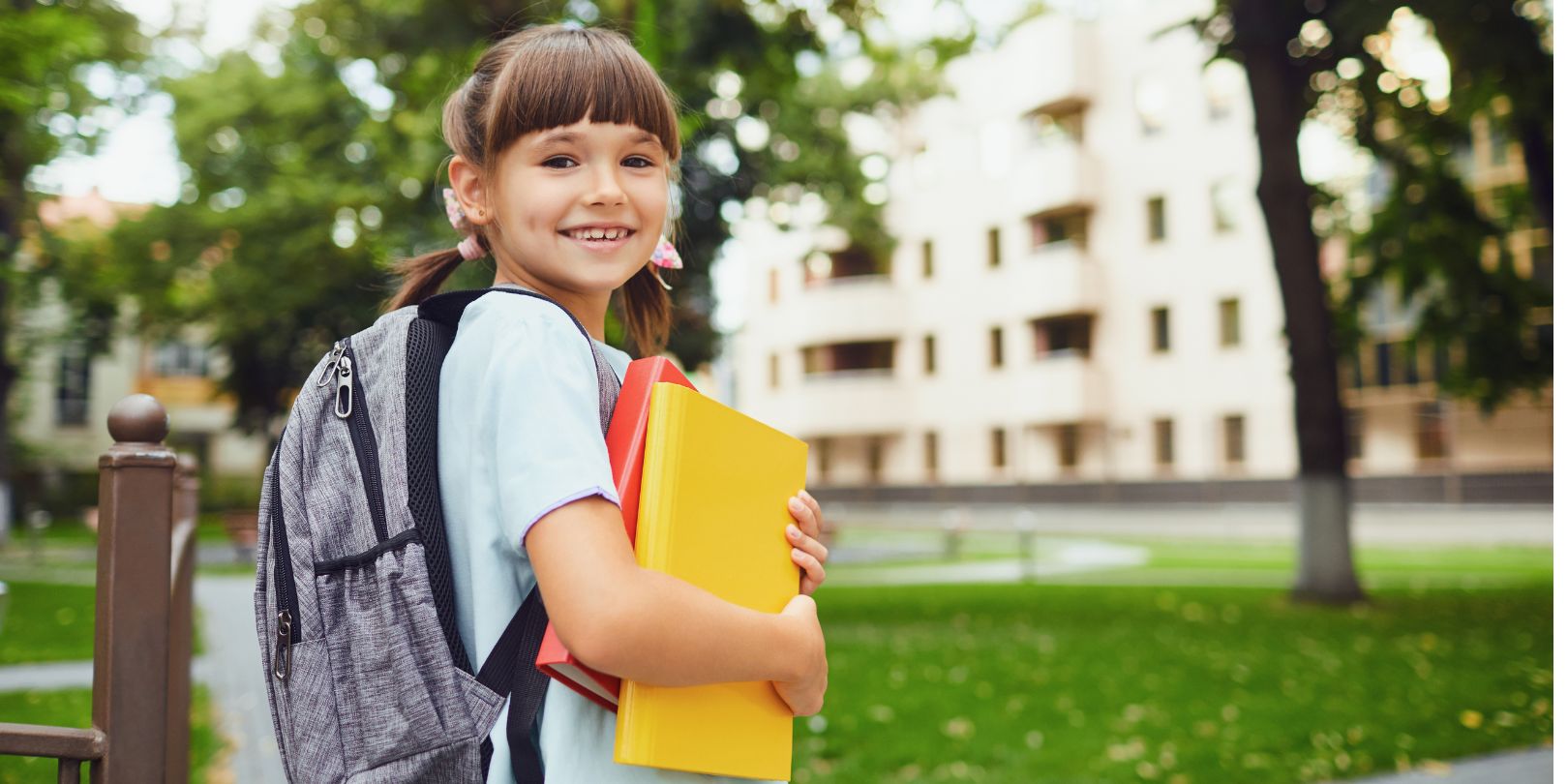 Happy Little Student Girl with a Backpack on Her Way to School.