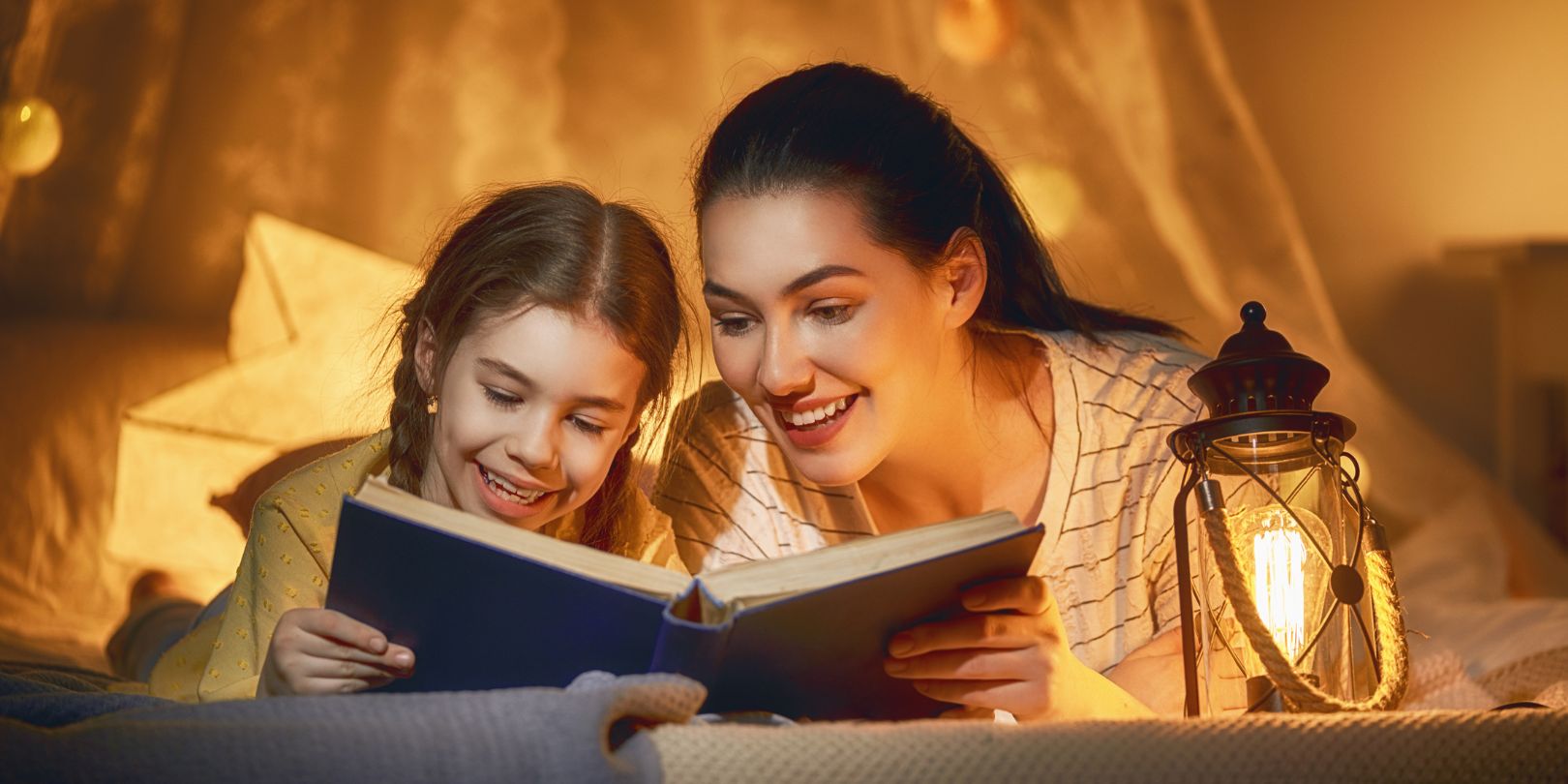 bedtime-stories-for-kids mighty-moms Family time. Pretty young mother reading a book to her daughter. Happy time at home.