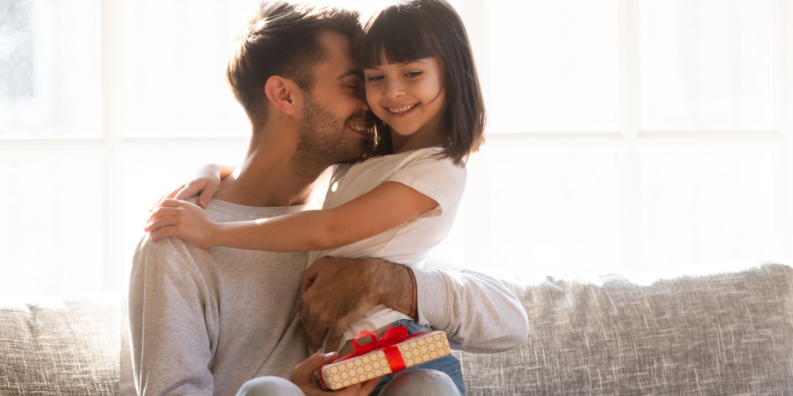 Grateful dad hugging daughter thanking for gift on fathers day