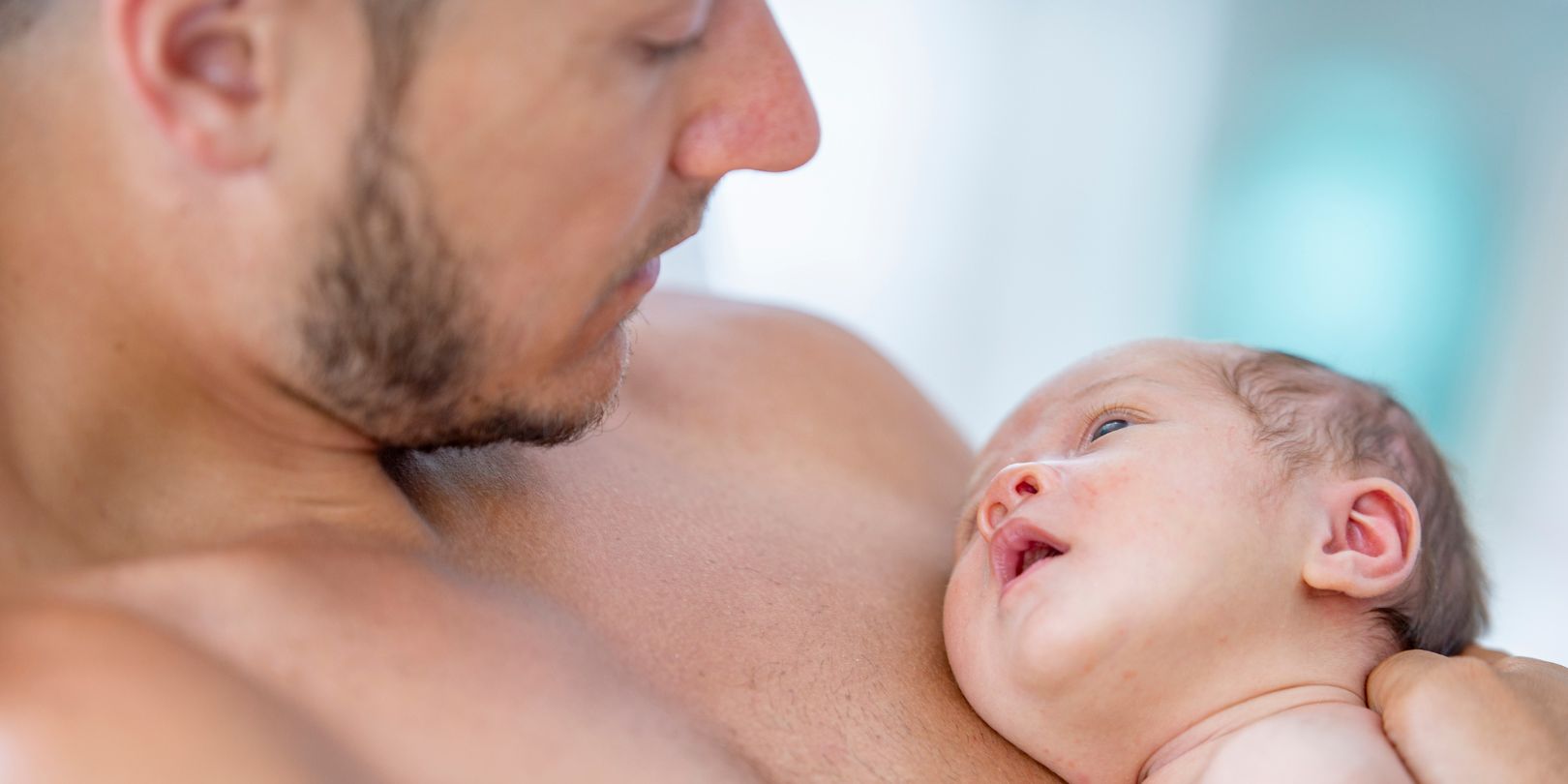 Father having skin to skin contact with newborn baby