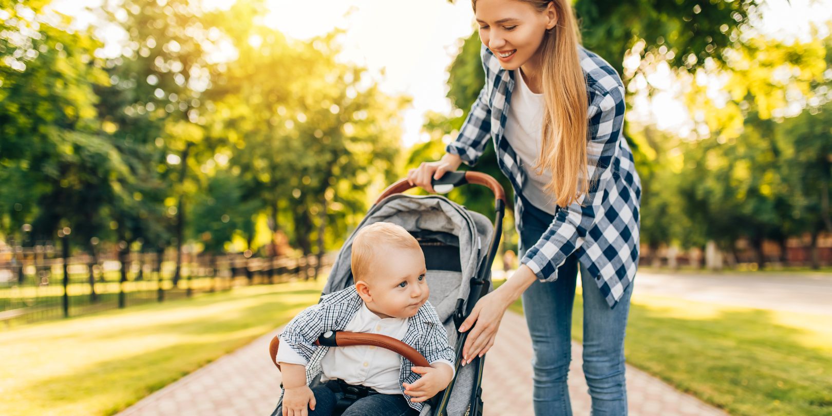 Mother Walks with a Baby Carriage and a Baby in the City