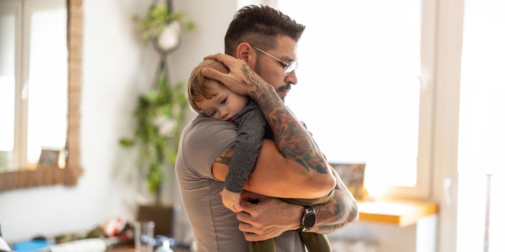 Dad putting to sleep baby boy in his arms