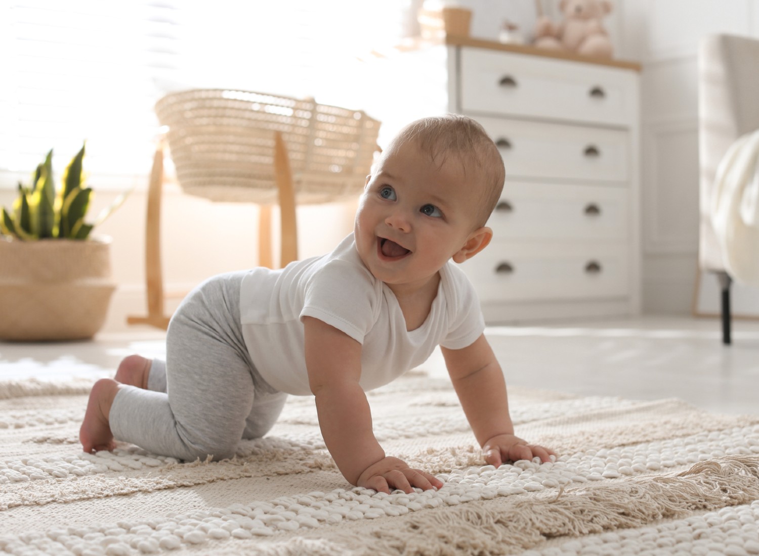 Happy baby crawling on white carpet