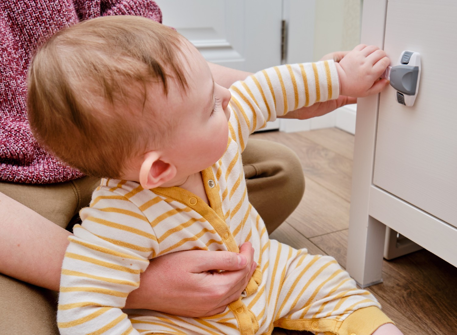 Baby playing with a cabinet lock