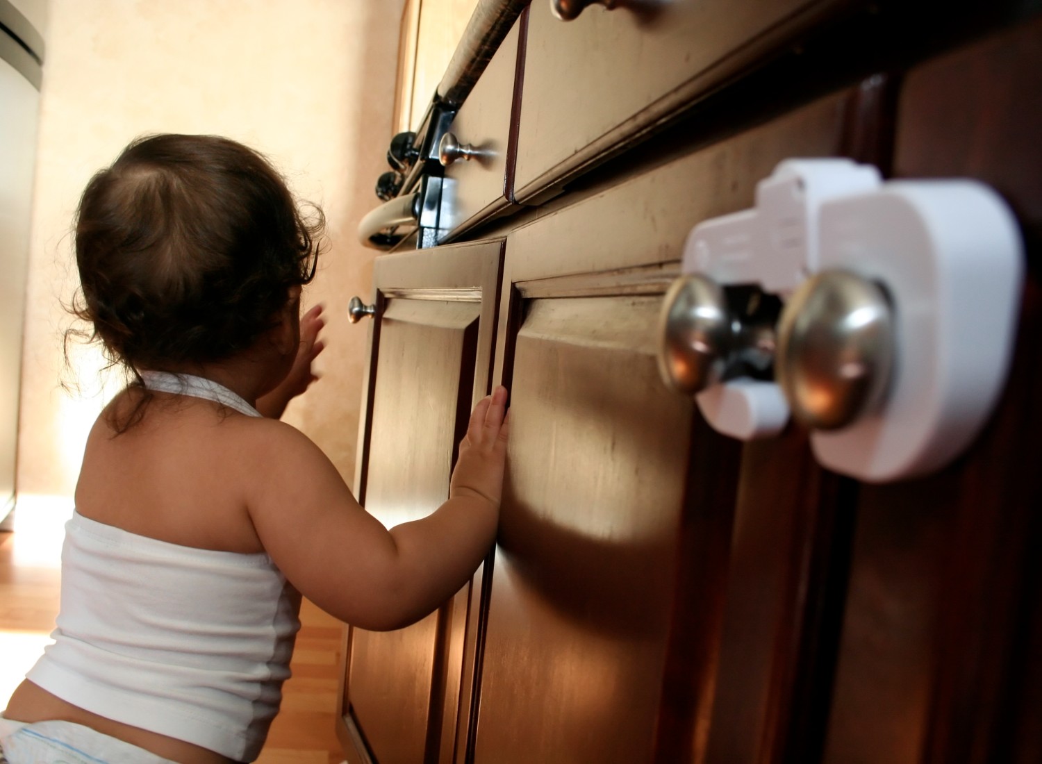 Child playing near locked cabinet