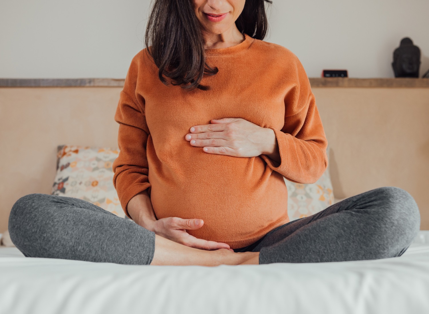 Pregnant woman sitting and holding her belly