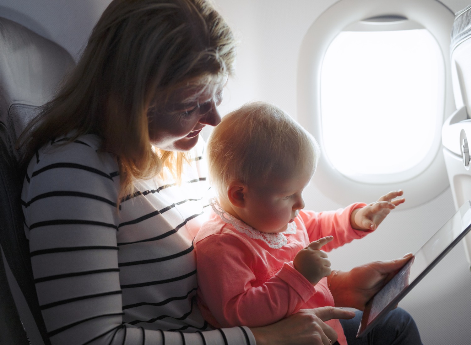 mom-and-child-playing-tablet-while-flying-on-plane.jpg_s=1024×1024&w=is&k=20&c=Z41V_JHfFgJ_hrrTuY23RcFyn5Ukps_dmLgaXf870YQ= Woman and baby on a plane using a tablet