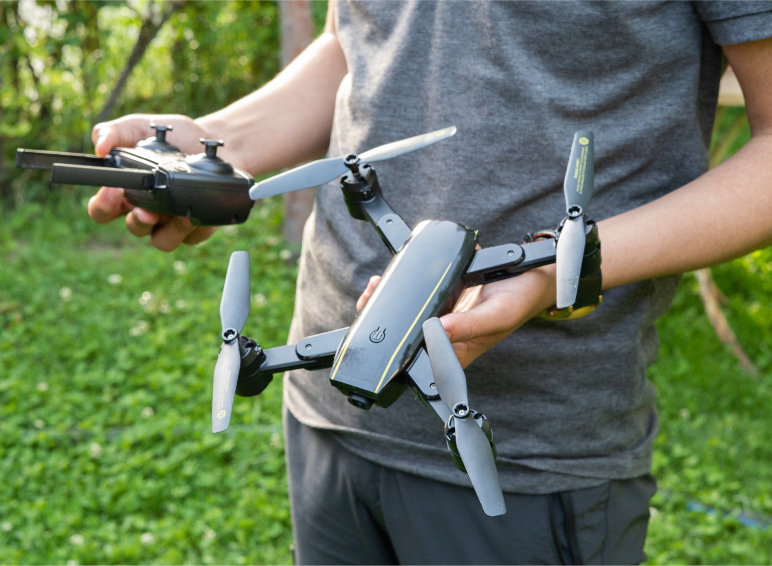 A boy holding a drone and remote