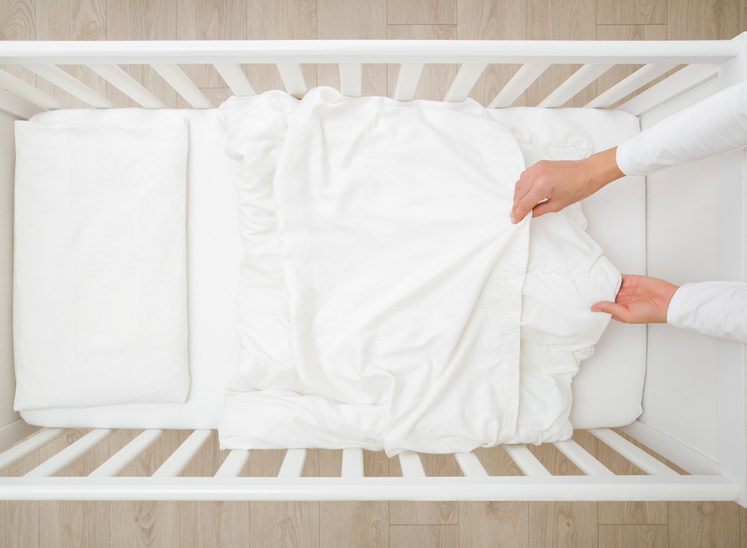 Woman changing crib bedding