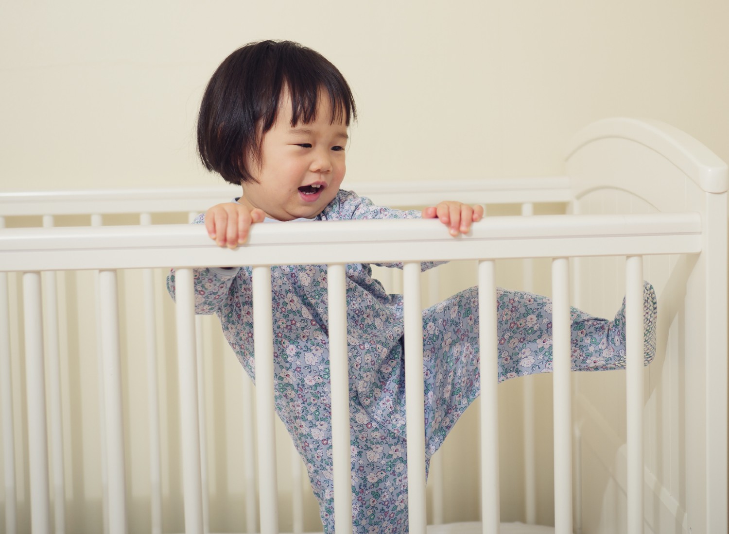 Toddler acting silly in a crib